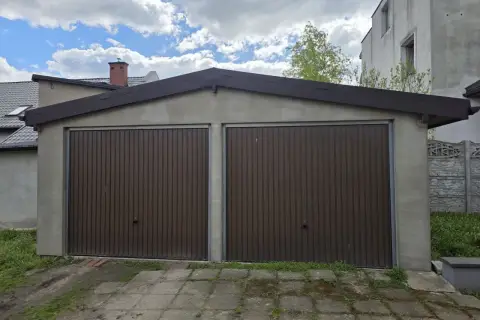 Dwa brązowe, segmentowe bramy garażowe w murowanym garażu. Zastanawiasz się, ile kosztuje wynajęcie garażu murowanego?