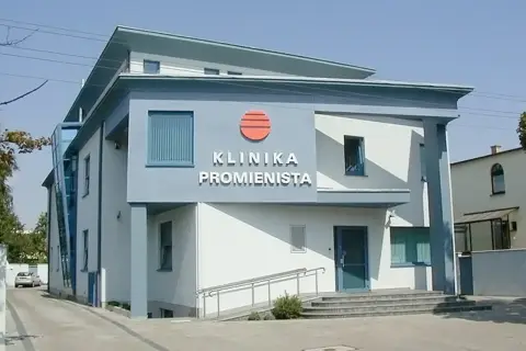 Nowoczesny budynek kliniki z napisem "KLINIKA PROMIENISTA" i logo.