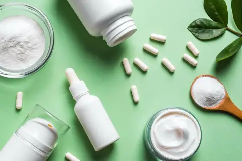Kollagenpulver, Kapseln und Cremes auf grünem Hintergrund. Mögliche kollagen nebenwirkung? Hier sind Produkte für Haut und Gelenke.