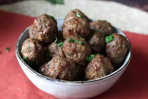 Succulente polpette in friggitrice ad aria, dorate e profumate, guarnite con prezzemolo fresco.