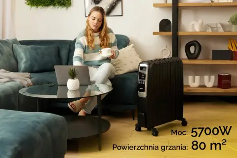 Kobieta z laptopem i kawą obok grzejnika olejowego. Sprawdź, ile prądu bierze grzejnik olejowy o mocy 5700W, ogrzewający 80 m².