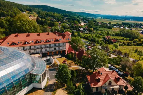 Kyriad Karkonosze: hotel z kopułą i basenem, otoczony zielenią i górami.