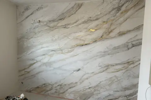 Ściana pokryta efektowną glinką wenecką imitującą marmur z subtelnymi złotymi żyłkami.