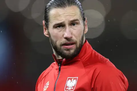 Piłkarz w czerwonej bluzie z orłem na piersi, w deszczu. Krychowiak gdzie gra? Na boisku, w barwach narodowych.