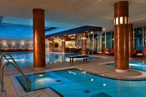Basen hotelowy z leżakami i dekoracjami ściennymi.