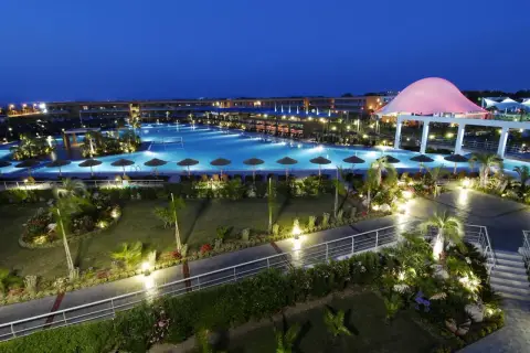 Piękny resort z basenem i palmami nocą. Wiele pozytywnych blue lagoon resort opinie potwierdza jego urok.