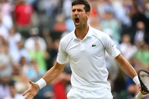Emocjonalny tenisista Djokovic krzyczy z kortu, świętując zwycięstwo.