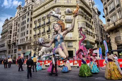 Gigantescas figuras de fantasía, como un dragón rosa y una mujer con un pegaso, dominan la calle en las Fallas 2026.