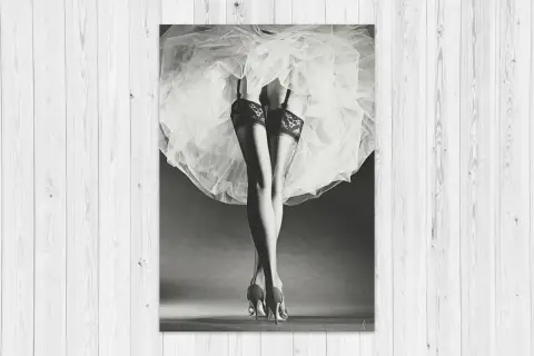 Nogi w pończochach i szpilkach, ukryte pod zwiewną spódnicą. Klasyka w stylu Horst P. Horst.