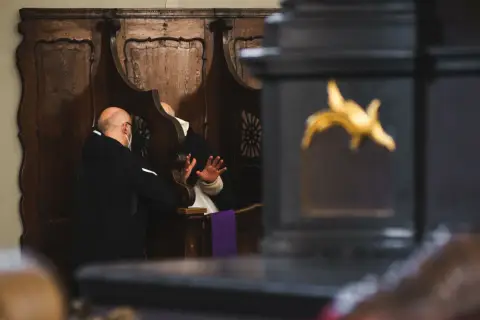 Spowiedź w konfesjonale. Mężczyzna w masce wyznaje swoje grzechy ciężkie, lista jest długa.