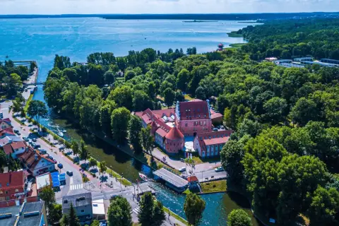 Malowniczy hotel na Mazurach, otoczony zielenią i wodą, z widokiem na jezioro. Idealne miejsce na wypoczynek.