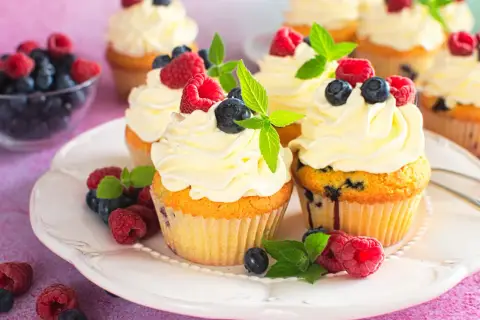 Pyszne babeczki z mascarpone, udekorowane malinami, borówkami i miętą. Idealne na deser!