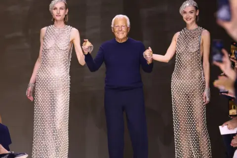 Giorgio Armani z modelkami w błyszczących kreacjach, uosobienieicono couture.