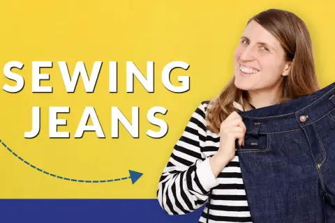 Woman smiles, holding up a pair of dark denim jeans, with "SEWING JEANS" text.