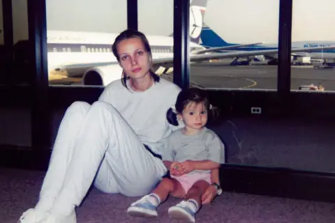 Agnieszka Kotlarska z córką na lotnisku, w tle samoloty British Airways i El Al.