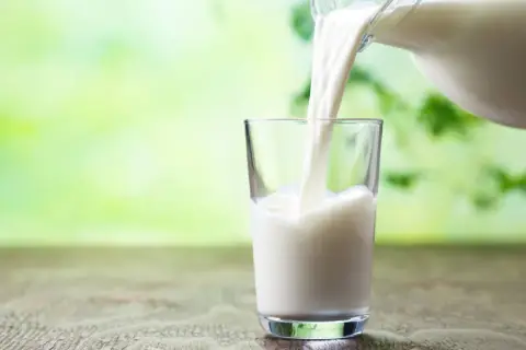 Versando latte fresco in un bicchiere, un'opzione salutare per chi cerca latte che non fa ingrassare.