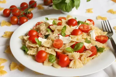 Makaron farfalle z pomidorkami koktajlowymi i mozzarellą. Proste przepisy na kuchnię śródziemnomorską.