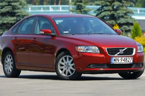 Czerwone Volvo S40 II z polskimi tablicami rejestracyjnymi WN 94827 zaparkowane na zewnątrz.