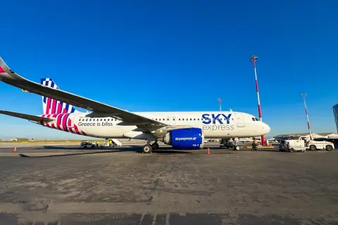 Samolot greckich linii lotniczych Sky Express na płycie lotniska. Napis "Greece is bliss" zapowiada podróż.