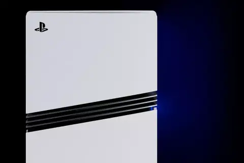 Biała konsola PlayStation 5 leży poziomo, z niebieskim światłem emanującym z bocznego otworu wentylacyjnego.