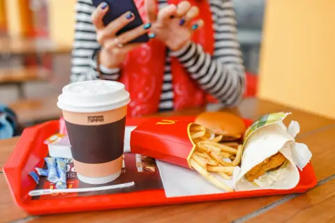 Taca z McDonald's: frytki, burger, wrap i kawa. Idealny zestaw na szybki lunch, choć warto pamiętać o jego kaloryczności.