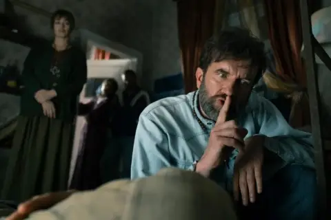 Sebastian Keller, jego żona i inni w tajemniczej scenie.