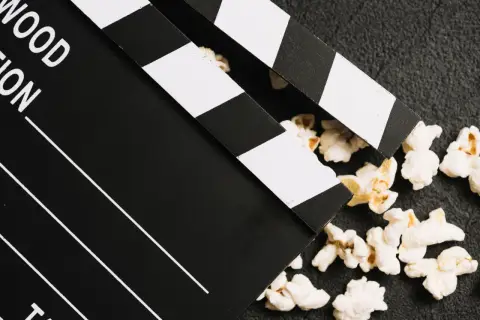Klapka filmowa i popcorn – idealne połączenie do oglądania polskich filmów kinowych.