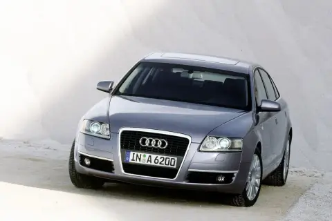 Szary Audi C6 z tablicą rejestracyjną IN A 6200 stoi na piaszczystym podłożu.