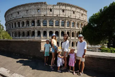 Famille profitant de Rome avec des enfants devant le Colisée.