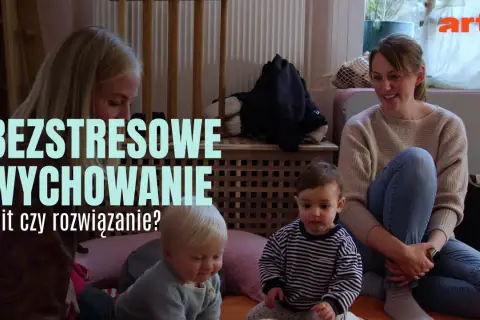 Dwie kobiety i dwoje niemowląt siedzą na podłodze.