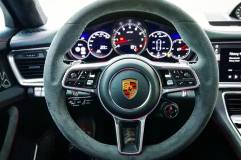 Kierownica Porsche Panamera GTS z alcantary, z emblematem Porsche i wskaźnikami GTS.