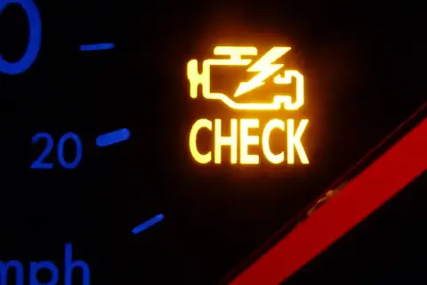 Żółta kontrolka silnika z napisem "CHECK" na desce rozdzielczej samochodu.