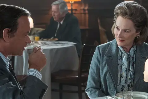 Tom Hanks i Meryl Streep w scenie z filmu "Czwarta władza", dyskutują przy stole.