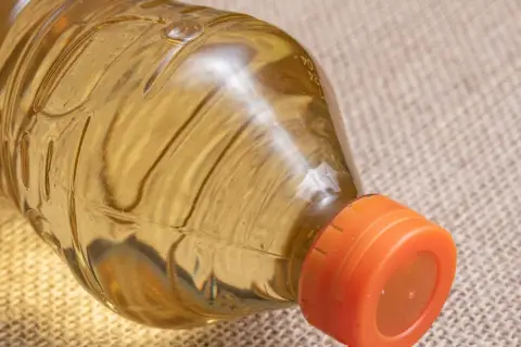 Pusta butelka po oliwie z pomarańczową zakrętką. Zastanawiasz się, gdzie wyrzucić butelkę po oliwie?