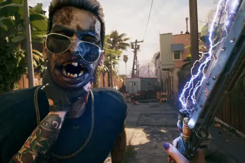 Zombi w okularach przeciwsłonecznych i z łańcuchem na szyi, trzymający broń zasilaną elektrycznością. Czy to zapowiedź Dead Island 2 crossplay?