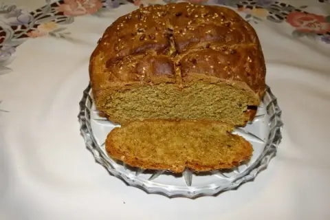Pyszny, domowy chleb pytlowy z ziarnami na wierzchu, pokrojony na talerzyku.