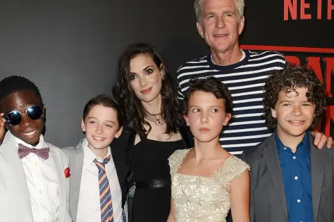 Aktorzy z "Stranger Things" pozują do zdjęcia. Millie Bobby Brown, która gra Eleven, wygląda na około 16 lat, co sugeruje, że w 4. sezonie mogła mieć podobny wiek.