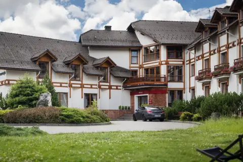 Elegancki hotel premium Wisła z drewnianymi elementami architektonicznymi i zadbanym ogrodem.