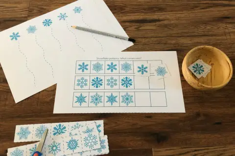 Actividades invierno Montessori: hojas con copos de nieve para recortar y completar patrones. Tijeras y lápiz listos.
