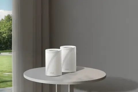 Un routeur extérieur sur un poteau et deux routeurs Deco sur une table. Ces appareils connectent votre maison à Internet.