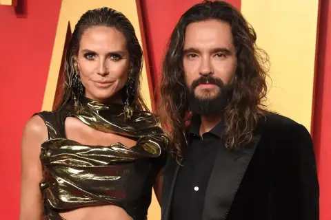 Heidi Klum i Tom Kaulitz na czerwonym dywanie, ona w złotej kreacji, on w czarnym garniturze.