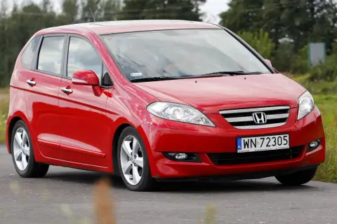 Czerwona Honda FR-V w ruchu drogowym, z widocznym numerem rejestracyjnym WN 72305.