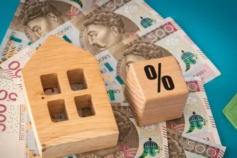 Drewniany domek i kostka z procentem na banknotach 500 zł. Wibor 3m prognozy.