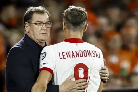Trener Czesław Michniewicz obejmuje Roberta Lewandowskiego po meczu. To symboliczne wsparcie przed kolejnymi powołaniami do kadry.