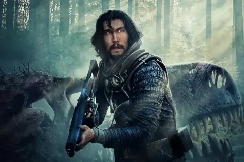Adam Driver w futurystycznym stroju z bronią, obok szkieletu dinozaura. Scena z jednego z jego filmów.
