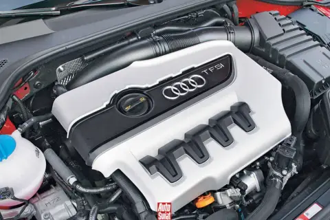 Silnik 2.0 TFSI z Audi A5, gotowy do pracy. Widoczna pokrywa silnika z logo Audi i oznaczeniem TFSI.