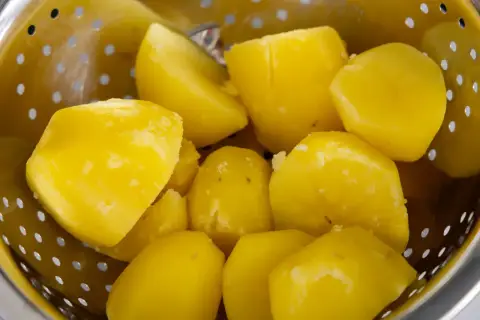Gotowane ziemniaki w durszlaku. Czy ziemniaki są zdrowe? Tak, to sycący i pożywny dodatek do wielu dań.