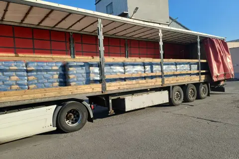 Na palecie ciężarówki ułożono worki z cementem. Widać ich sporo, gotowych do transportu.