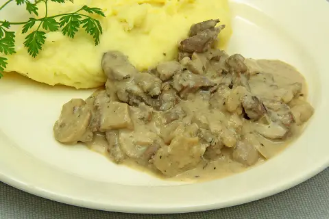 Rognons de porc en sauce crémeuse avec des champignons, servis avec une purée de pommes de terre onctueuse. Parfait pour savoir avec quoi accompagner des rognons de porc.