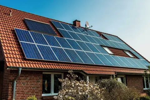 Dom z panelami fotowoltaicznymi na dachu. Instalacja fotowoltaika na starych zasadach, czerpiąca energię ze słońca.